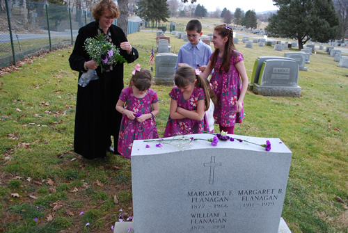 Christine and the kids around Catie’s grave at Calvary Cemetery
