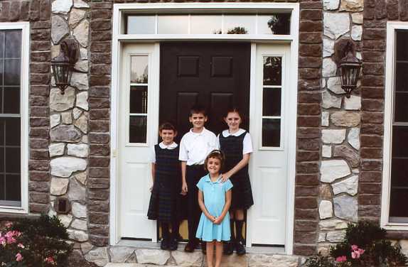 The first day of school at St. Joseph’s in Mechanicsburg, PA.  Catie, Mia, Maggie, and Max stand in front of their new home 