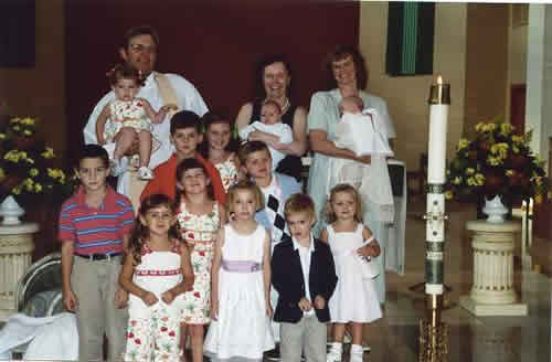 M.E.’s Baptism at St. Columbkill with Fr. Keith.  Fr. Keith and many of Catie’s cousins pictured here would accompany Catie to Lourdes in the weeks before she died.